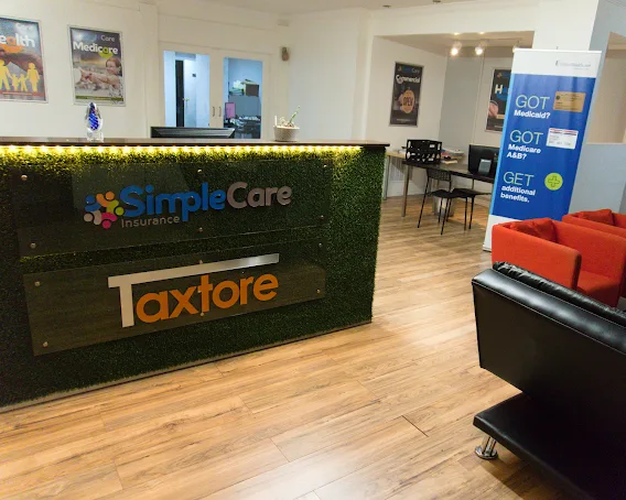 El mostrador de la oficina de SimpleCare Insurance en Miami, con su letrero y la sala de espera al fondo.